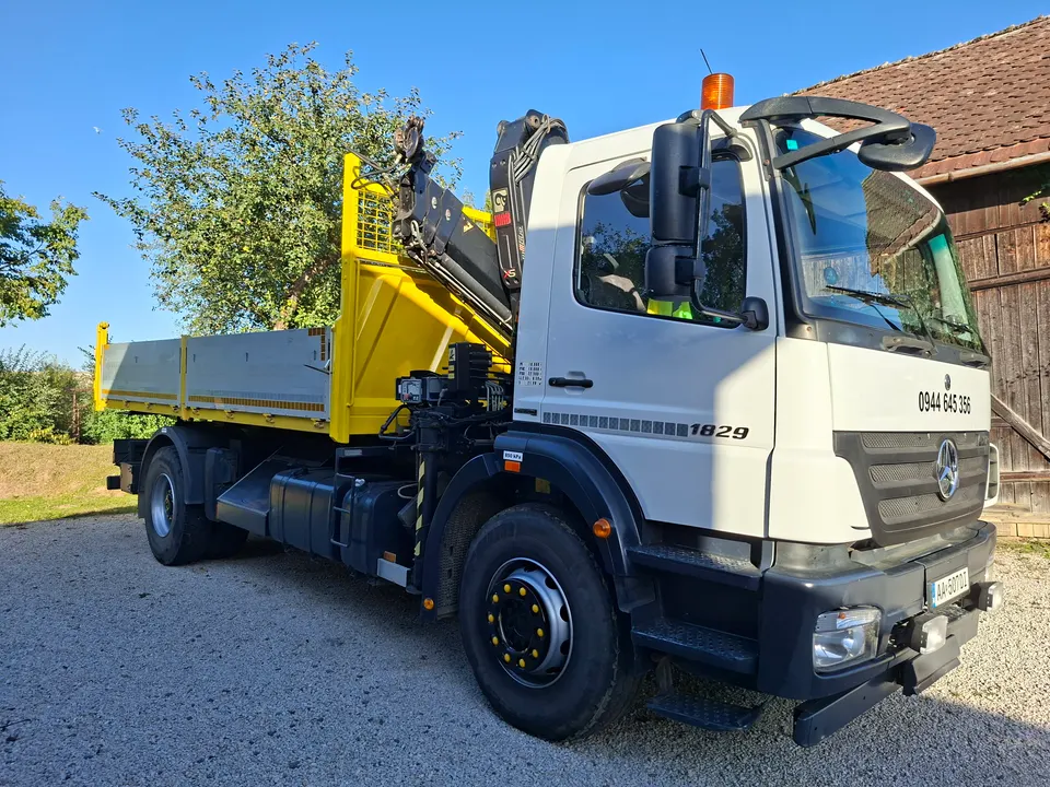 Nákladné vozidlo Mercedes Benz Axor s hydraulickou rukou HIAB pri nakládke stavebného materiálu